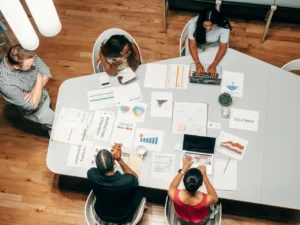 Profissionais discutindo estratégia de influencer marketing com gráficos e relatórios sobre a mesa.